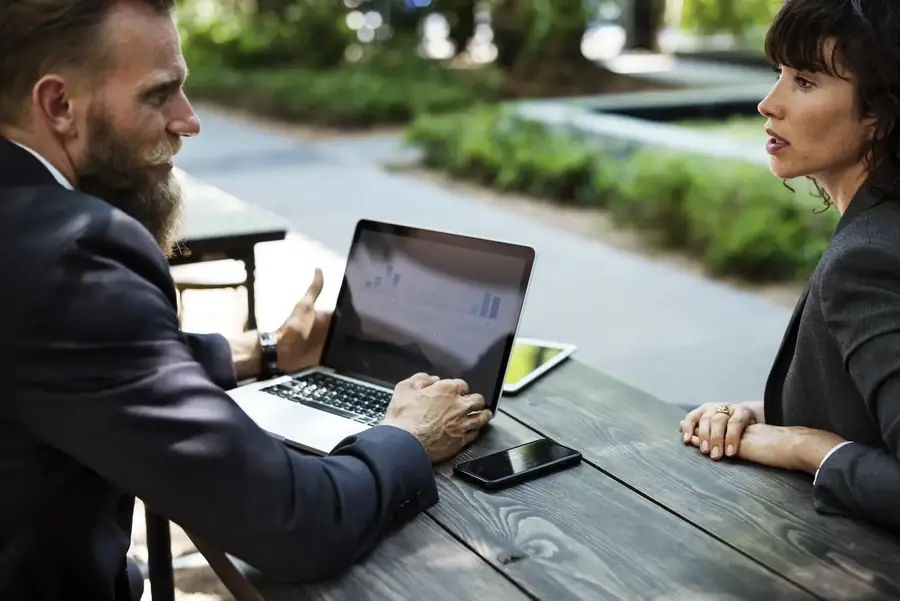 Two colleagues discussing strategy over a laptop