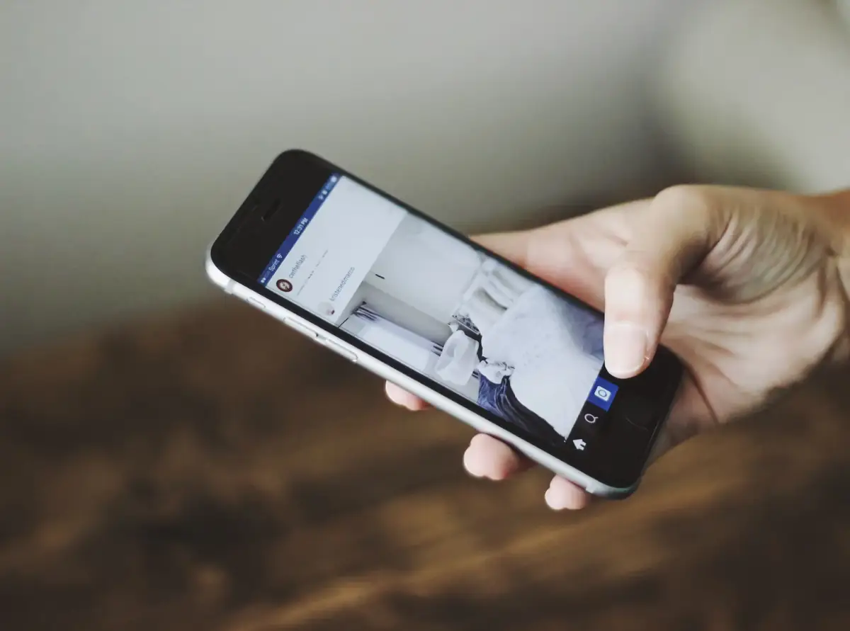 Hand scrolling a social media feed on a phone